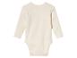 Een crèmekleurige baby romper met lange mouwen.