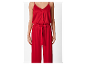 Rode jumpsuit met knopen en ceintuur.
