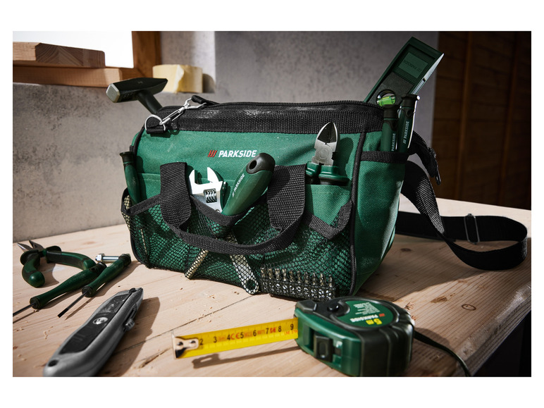 Een groene gereedschapstas met een Parkside meetlint, tang en schroevendraaiers.