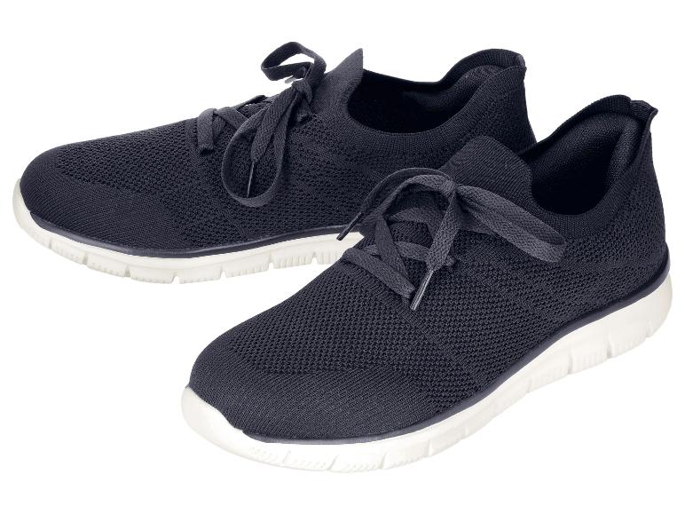 Een paar zwarte gebreide sportschoenen met witte zolen