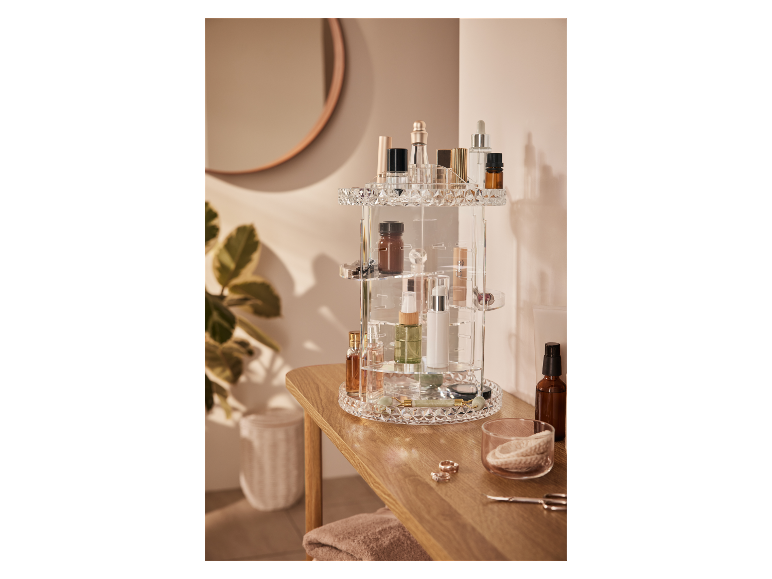 Een draaiende make-up organizer van acryl gevuld met diverse beautyproducten.
