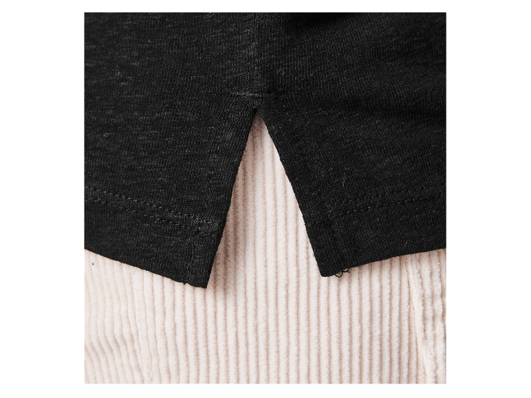 Close-up van een zwart katoenen shirt en beige corduroy broek.