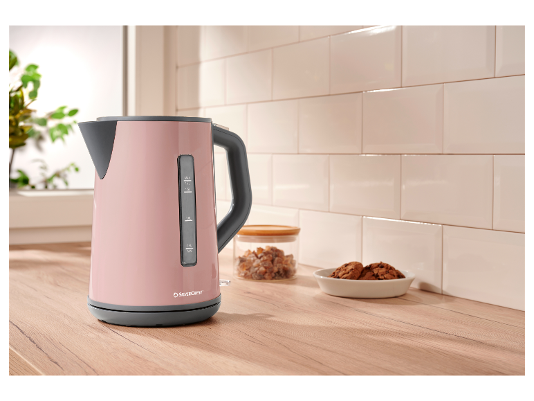 Een roze SilverCrest waterkoker op een houten aanrecht.