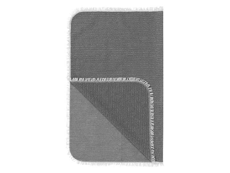 Grijze plaid met franjes.