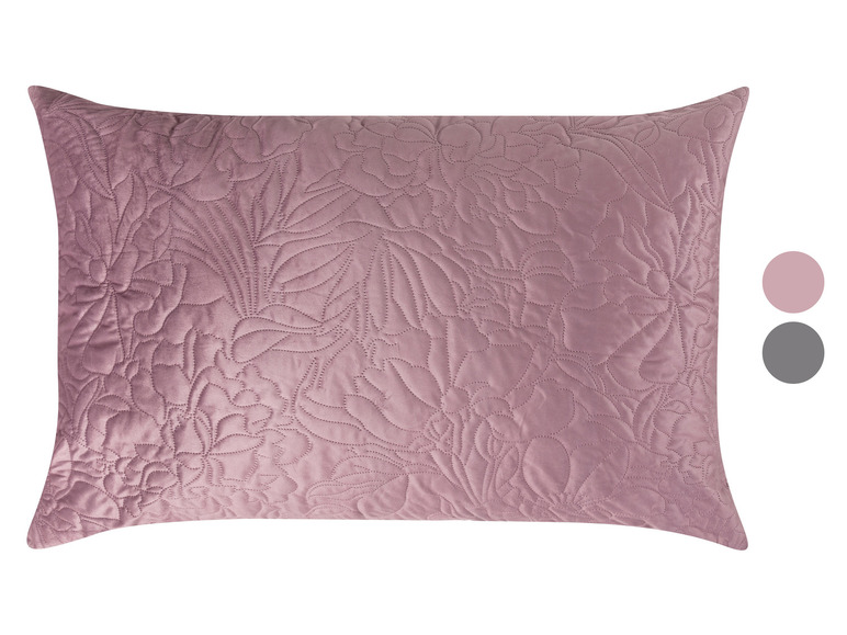 Een roze kussen met bloemenmotief.