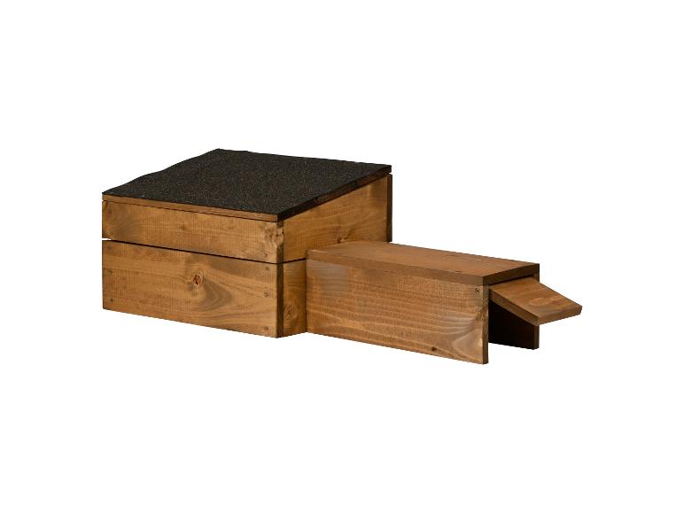 Houten dierenhok met een vilten dak en een oprit.