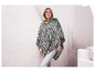 Een vrouw draagt een zwarte en witte zebraprint poncho.