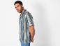 Man draagt een blauw-beige gestreept overhemd.