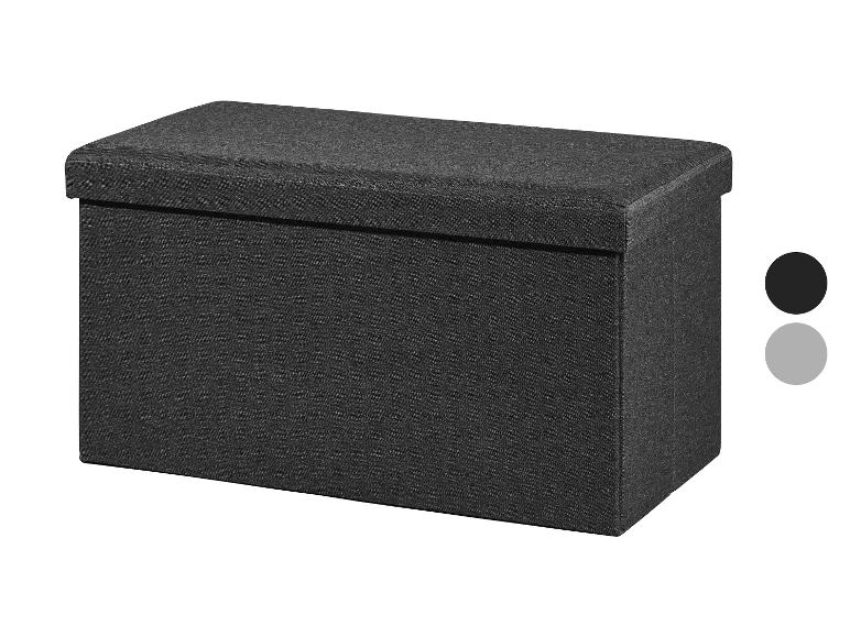 Een donkergrijze opbergpoef van stof met een gestoffeerde bovenkant.