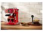 Rood espressomachine met twee glazen koffie, een schaal koekjes en koffiebonen.