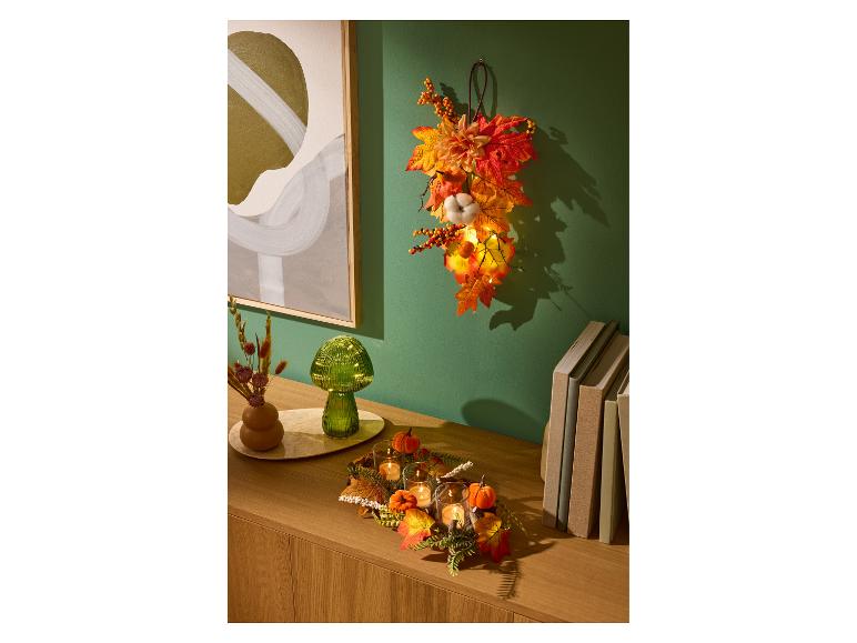 LIVARNO home herfstdecoratie met ledverlichting, kaarsen en kleurrijke bladeren.