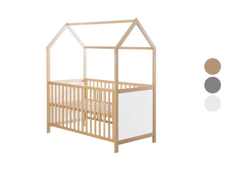 Een houten babybed met een huisvormig dakje