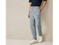 Man draagt blauwe cargo broek met witte sneakers.