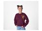 Lachend meisje in een bordeauxrode sweatshirt met een 'Croissant Club'-afbeelding en blauwe jeans.