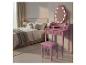 Roze kaptafel met verlichte spiegel en kruk in een slaapkamer