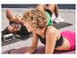 Twee personen doen oefeningen met push-up bars en Crivit yogamatten.
