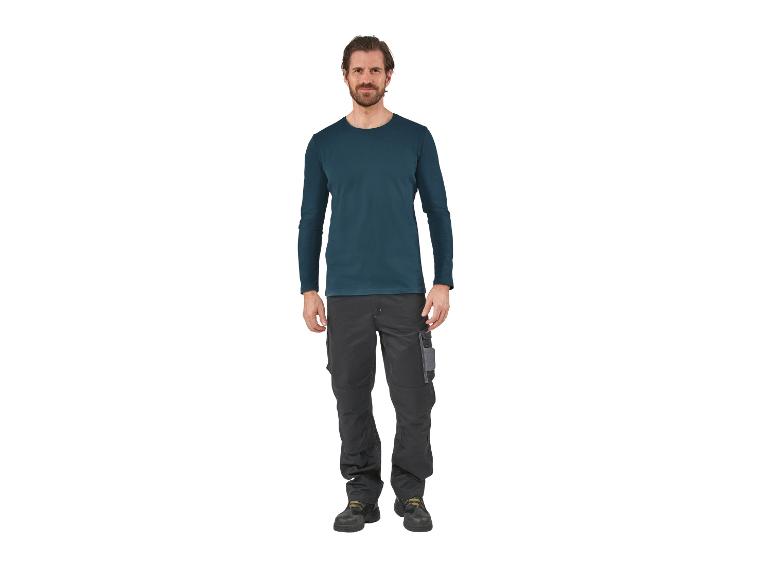 Man draagt een donkerblauw shirt met lange mouwen en een grijze werkbroek.