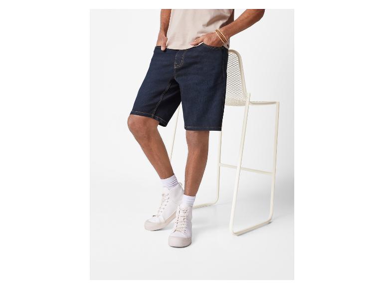 Herenshorts van jeans en witte sneakers.