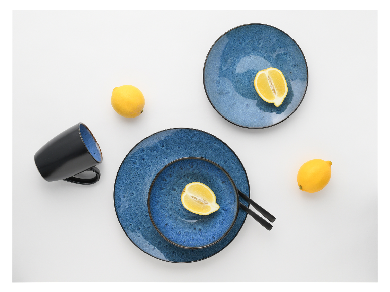 Blauw servies, zwarte mok en citroenen.