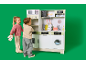 Kinderen spelen met een houten speelgoedkeuken tegen een groene achtergrond.