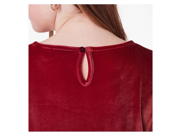 Close-up van de rug van een vrouw in een rode fluwelen jurk met knoopsluiting