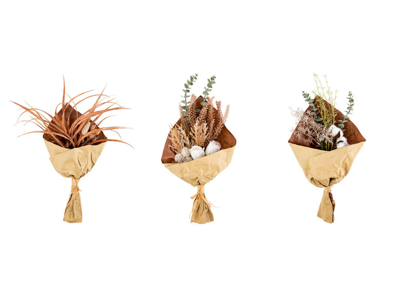 Drie boeketten met gedroogde bloemen en eucalyptus in bruin papier.