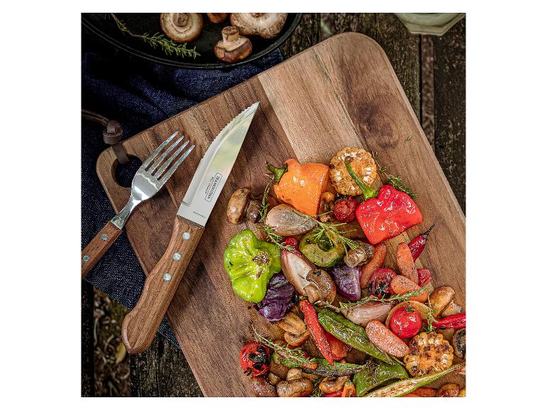 Gegrilde groenten op houten plank met bestek, champignons en kruiden.