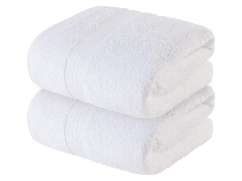 Twee zachte, witte handdoeken, op elkaar gelegd.