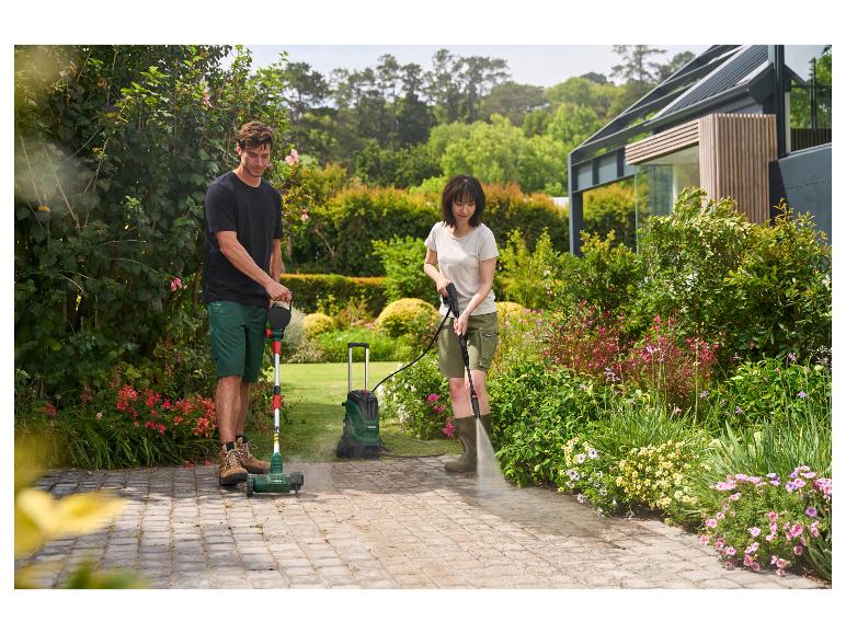 Man en vrouw reinigen terras met onkruidborstel en hogedrukreiniger.