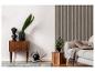 Moderne woonkamer met een houten ladekast, plant en lichtgrijze bank.