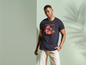 Man draagt een donkerblauw T-shirt met een tropisch printje en beige shorts.