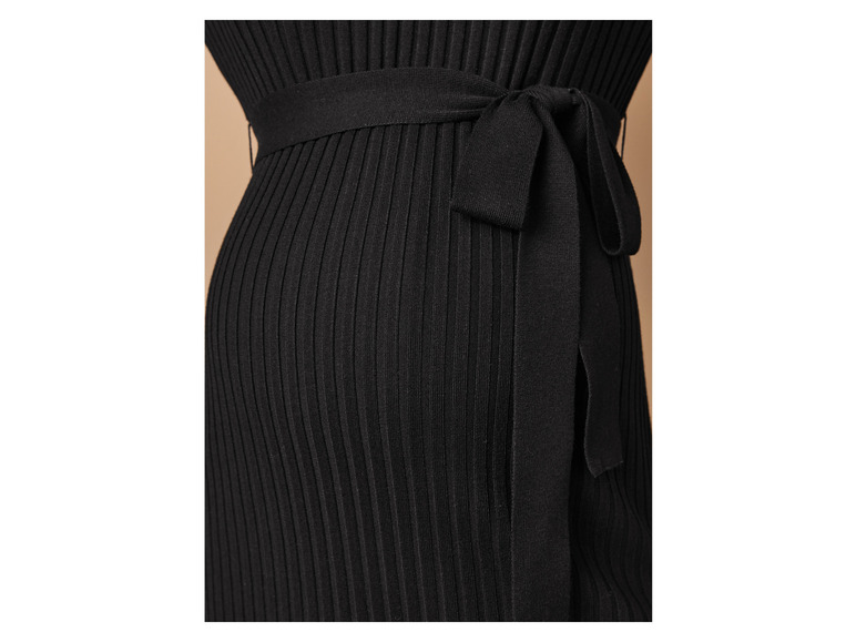 Detail van een zwarte gebreide jurk met ceintuur.