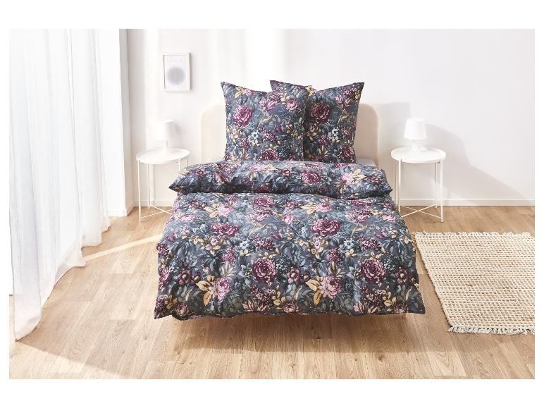 Bloemen beddengoed op een bed in een slaapkamer.