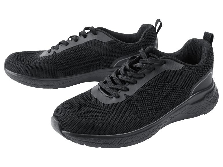 Een paar zwarte sportschoenen op een witte achtergrond.