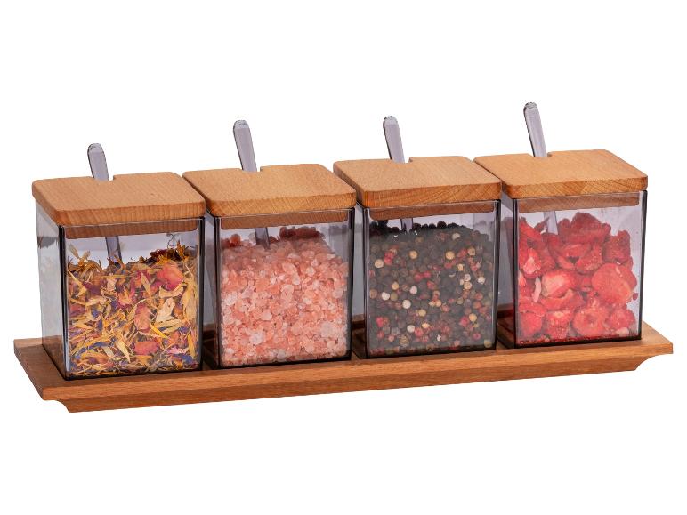 Kruiden, roze Himalaya-zout, peper en gedroogde aardbeien in houten potjes.