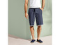 Man draagt blauwe shorts en blauwe espadrilles.