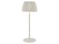 Witte vloerlamp met geplooide kap, die een warme gloed afgeeft.