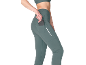Vrouw in teal sportlegging met telefoon in zijzak en een reflecterende streep.