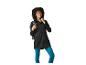 Vrouw in zwarte jas en blauwe legging met rugzak, glimlachend.