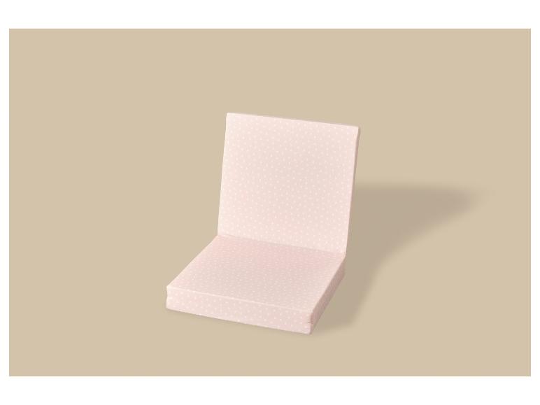 Roze kussen met wit hartjespatroon voor een stoel