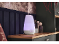 Een van kleur veranderende aromadiffuser die nevel afgeeft op een houten plank in een gezellige kamer.