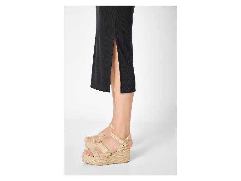 Vrouw in zwarte rok en espadrille-plateausandalen