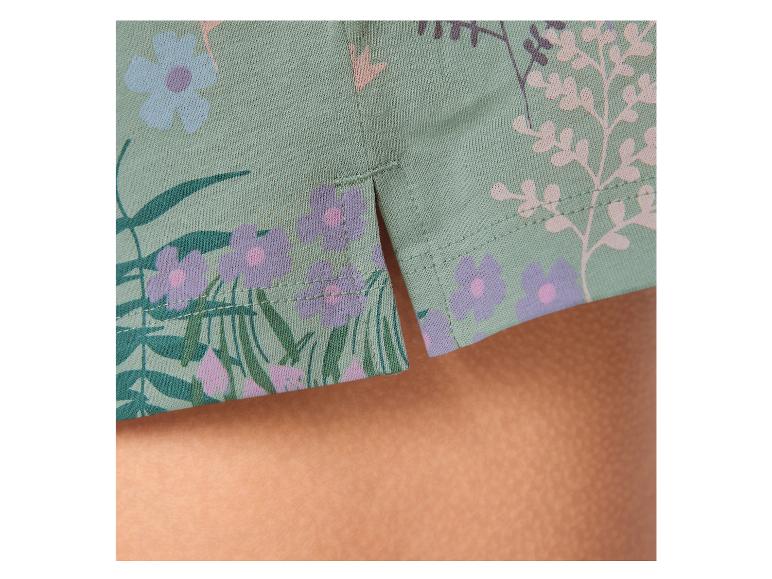 Detail van een mintgroen kledingstuk met bloemenprint en zijsplitten.