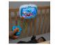 Een baby in een wieg kijkt naar een Baby Einstein speelgoed met aquatisch thema.