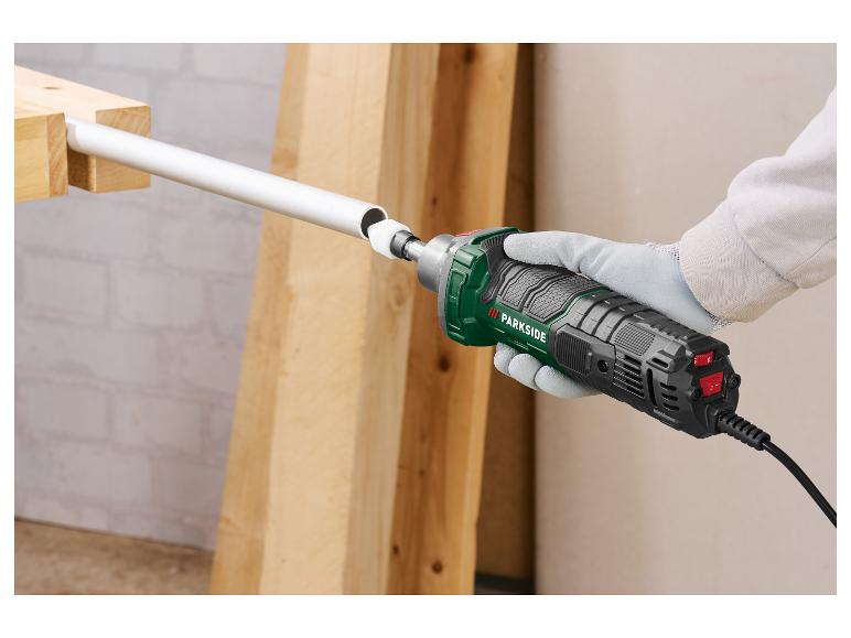 Een persoon gebruikt een Parkside schuurmachine om een witte pijp te schuren.