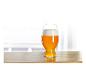 Een glas blond bier op een houten tafel.