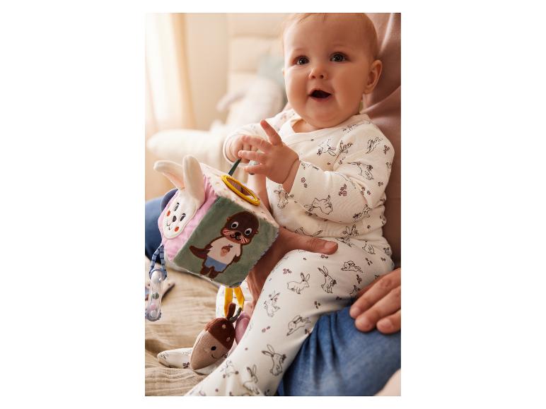 Een baby speelt met een zachte Sigikid-speelgoedkubus.