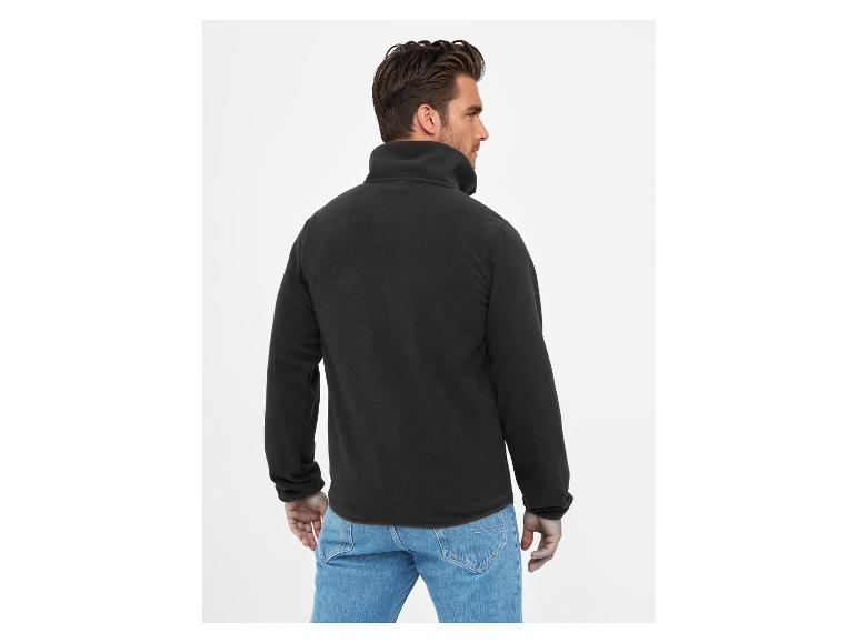 Zwart fleecejack voor heren en jeans, achteraanzicht.
