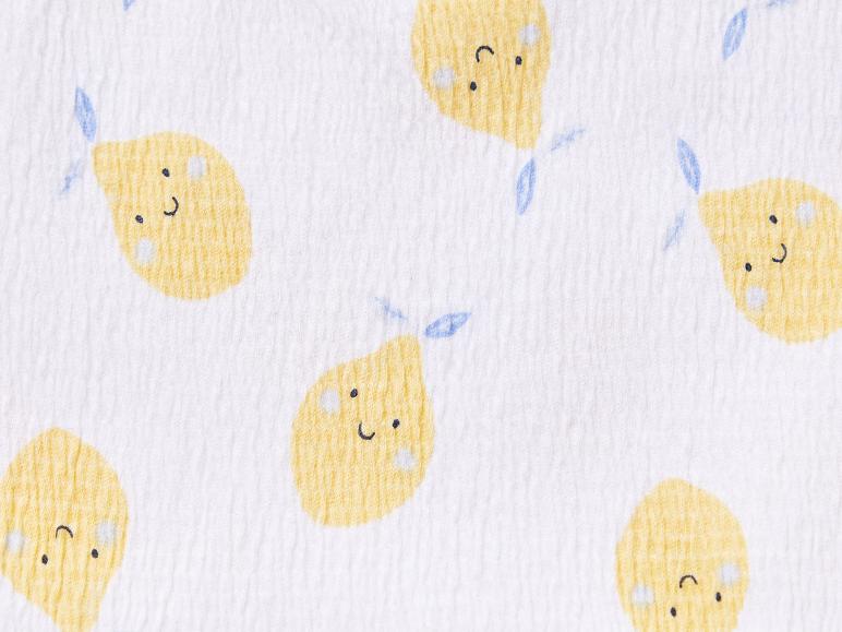 Witte stof met gele citroenen met gezichtjes.