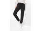 Vrouw in zwarte joggingbroek en witte sneakers, poserend met één been omhoog.